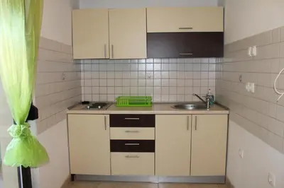 a small kitchen with white cabinets and a sink at Apartmani Čolić Vlašić in Vlasic