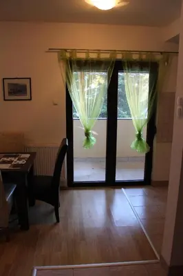 a room with a window with curtains and a table at Apartmani Čolić Vlašić in Vlasic