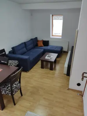 a living room with a blue couch and a table at Apartmani Čolić Vlašić in Vlasic