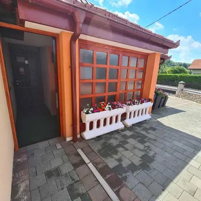 an orange building with flowers in a window at Hana Superior Apartments in Bihać