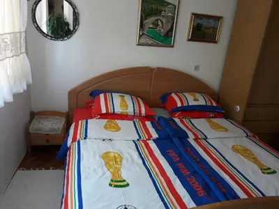 a bed with a bedspread with a football trophy on it at Apartment Sun in Visoko