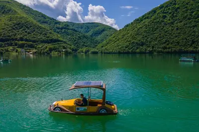 a man riding a yellow boat on a lake at Hotel Plivsko jezero in Jajce