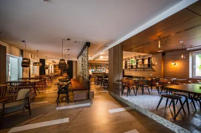a restaurant with wooden floors and tables and chairs at Hotel Plivsko jezero in Jajce
