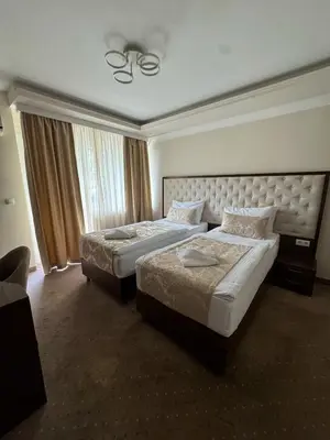 a hotel room with two beds and a large window at Hotel Turist 98 in Jajce