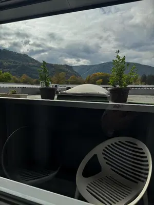 a white chair sitting on a balcony with two plants at Hotel Turist 98 in Jajce