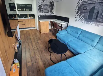a living room with a blue couch and a table at Hotel Turist 98 in Jajce