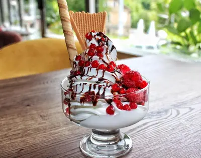 a dessert with ice cream and berries on a table at Hotel Turist 98 in Jajce