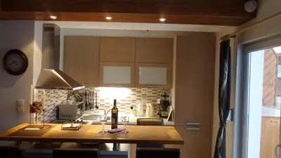 a kitchen with a table with a bottle of wine on it at Apartman Ena in Vlasic