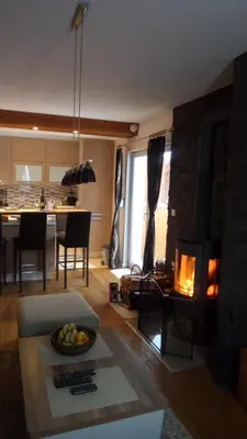 a living room with a fireplace and a dining room at Apartman Ena in Vlasic