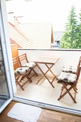 a balcony with two chairs and a table at Apartman Ena in Vlasic
