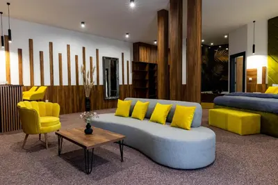 a living room with a couch and yellow chairs at Hostel Tron in Travnik