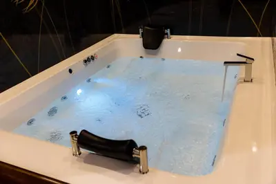 a bath tub filled with water with a faucet at Hostel Tron in Travnik