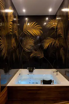 a bath tub in a room with a wall with plants at Hostel Tron in Travnik