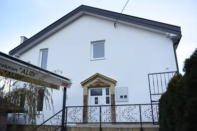 a white house with a black fence at Motel Alibi in Banja Luka