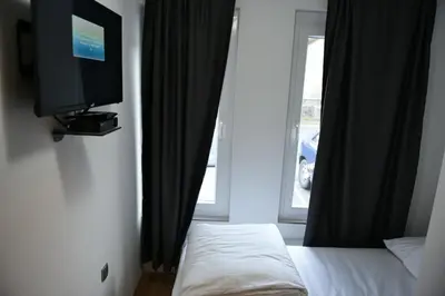 a bedroom with a tv and a bed and a window at Motel Alibi in Banja Luka