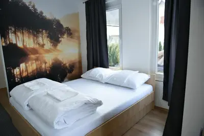 a bed with white sheets and a window at Motel Alibi in Banja Luka