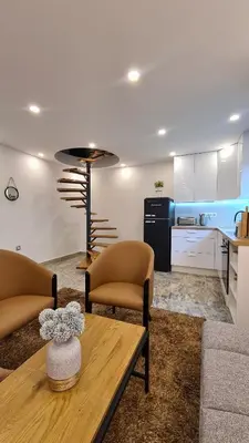 a living room with a table and chairs and a kitchen at Holiday Home Oaza Mira in Visoko