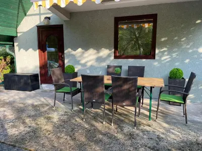 a table and chairs in front of a house at Holiday Home Oaza Mira in Visoko