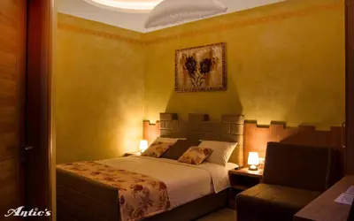 a bedroom with a bed and a chair at Motel pizzeria Antic's in Laktaši