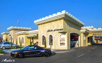 a black car parked in front of a store at Motel pizzeria Antic's in Laktaši