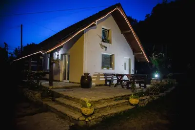 a small house at night with a table and chairs at Holiday Home Nektar Park in Bihać
