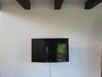 a flat screen tv hanging on a white wall at Holiday Home Nektar Park in Bihać