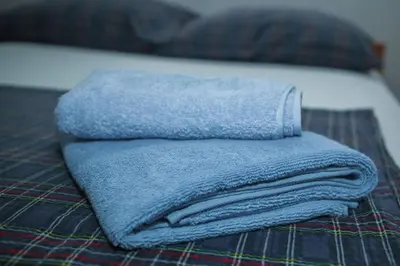 a blue towel sitting on top of a bed at Holiday Home Nektar Park in Bihać
