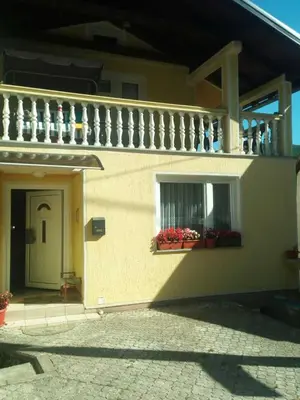 a building with a balcony and a window with flowers at Apartment Beganovic in Kulen Vakuf