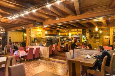 a man sitting at a table in a restaurant at Motel Orhideja in Donji Vakuf