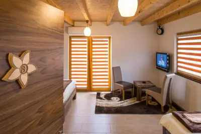a room with a door and a chair and a television at Motel Orhideja in Donji Vakuf