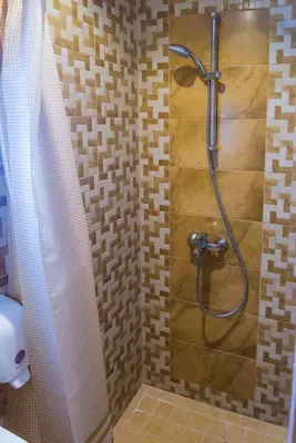 a shower with a hose in a bathroom at Motel Orhideja in Donji Vakuf