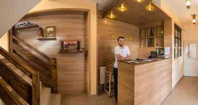a man standing at a counter in a room at Motel Orhideja in Donji Vakuf