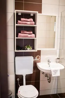 a bathroom with a toilet and a sink and towels at University Hotel Dorrah in Tuzla