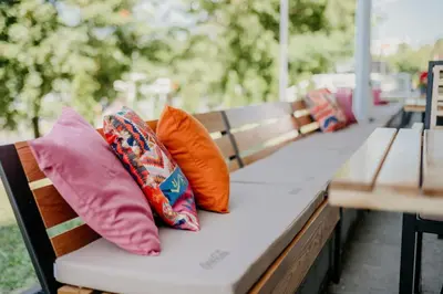 a row of pillows sitting on a bench at University Hotel Dorrah in Tuzla
