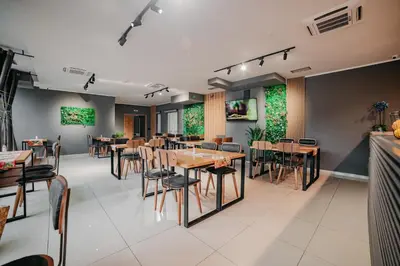 a restaurant with tables and chairs in a room at University Hotel Dorrah in Tuzla