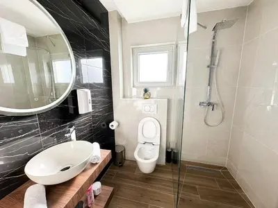 a bathroom with a sink and a toilet and a mirror at Apartmani Mila in Laktaši