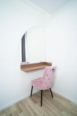 a pink chair sitting in front of a mirror at Apartmani Mila in Laktaši