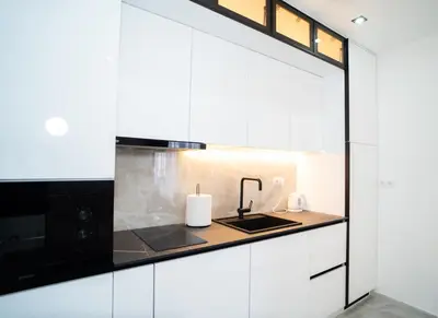 a kitchen with white cabinets and a sink at Apartmani Mila in Laktaši