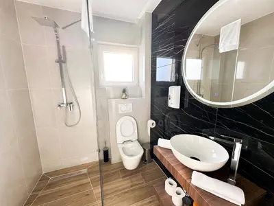 a bathroom with a sink and a toilet and a mirror at Apartmani Mila in Laktaši