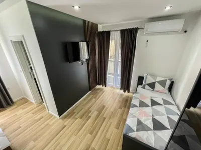 a room with a bed and a black wall at Apartmani Mila in Laktaši