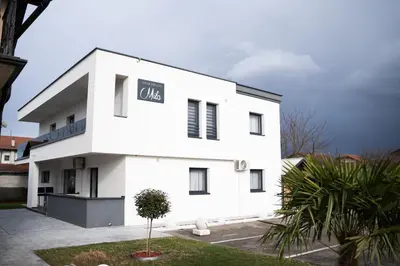 a white building with a sign on it at Apartmani Mila in Laktaši