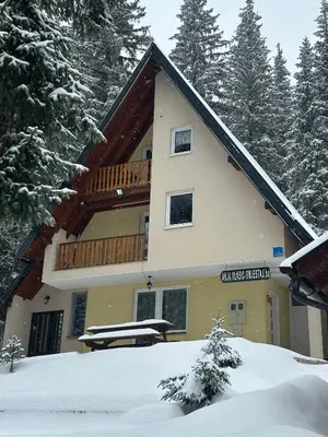 a large building with a balcony in the snow at Vikendica Anja in Vlasic