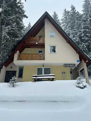 a house with a balcony and a bench in the snow at Vikendica Anja in Vlasic