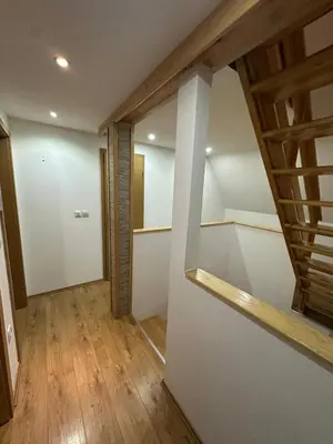 an attic room with a staircase and wooden floors at Vikendica Anja in Vlasic