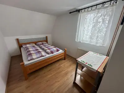 a small bedroom with a bed and a table at Vikendica Anja in Vlasic