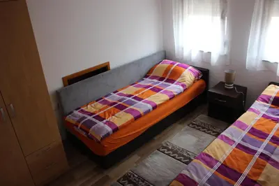 a bedroom with two twin beds and a window at Apartments Zoni in Vlasic