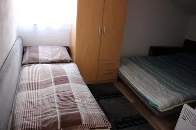 a bedroom with two beds and a cabinet at Apartments Zoni in Vlasic