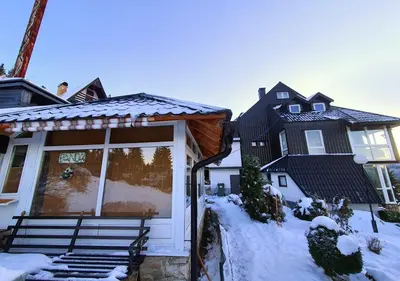 a house with a porch in the snow at Apartments Panda in Vlasic
