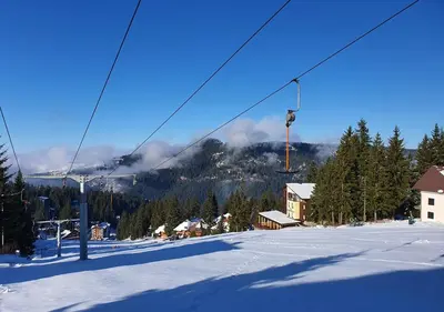 a ski lift in front of a snow covered mountain at Apartments Panda in Vlasic