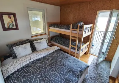 a bedroom with two bunk beds and a balcony at Apartments Panda in Vlasic